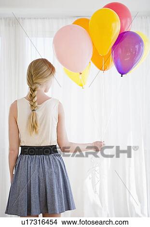 Woman holding bunch of colorful balloons View Large Photo Image Picture - Woman holding bunch of colorful balloons. Fotosearch