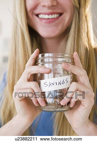 Woman holding jar with savings View Large Photo Image Stock Image - Woman holding jar with savings. Fotosearch
