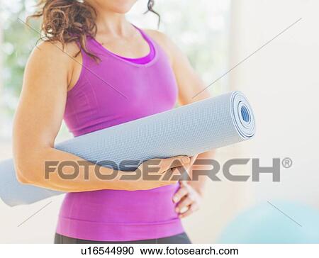 Woman holding rolled up yoga mat View Large Photo Image Stock Image - Woman holding rolled up yoga mat. Fotosearch