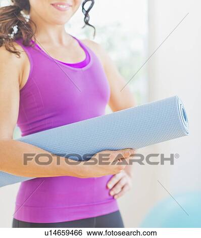 Woman holding rolled up yoga mat View Large Photo Image Stock Photograph - Woman holding rolled up yoga mat. Fotosearch