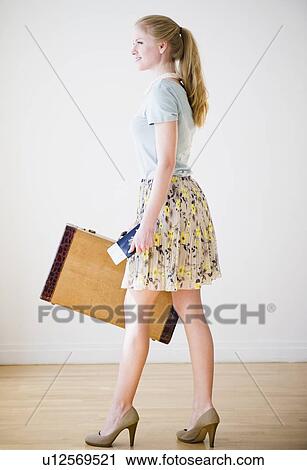 Woman holding suitcase and passport View Large Photo Image Stock Image - Woman holding suitcase and passport. Fotosearch
