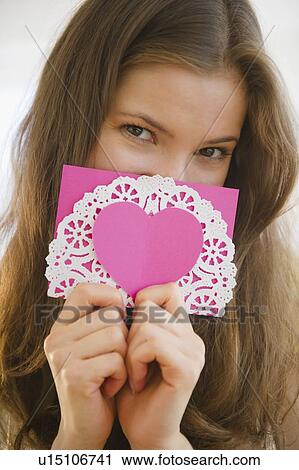 Stock Image - Woman holding valentine card. Fotosearch
