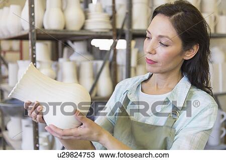 Woman holding vase in pottery warehouse View Large Photo Image Stock Image - Woman holding vase in pottery warehouse. Fotosearch
