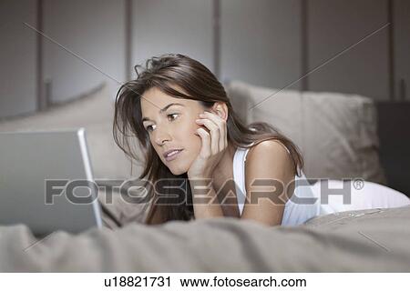 Woman in bed using laptop View Large Photo Image Stock Image - Woman in bed using laptop. Fotosearch