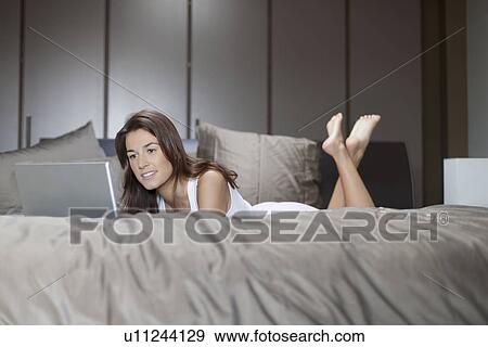 Woman in bed using laptop View Large Photo Image Stock Photo - Woman in bed using laptop. Fotosearch