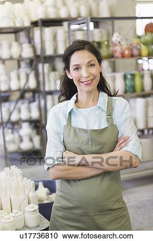 Stock Image - Woman in pottery warehouse. Fotosearch