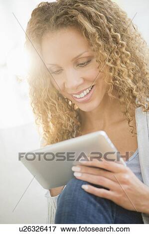 Stock Photo - Woman looking at tablet pc. Fotosearch