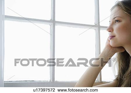 Woman looking through window View Large Photo Image Stock Image - Woman looking through window. Fotosearch