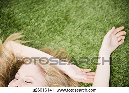 Woman lying on grass View Large Photo Image Stock Image - Woman lying on grass. Fotosearch