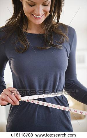 Woman measuring herself with measuring tape View Large Photo Image Stock Photo - Woman measuring herself with measuring tape. Fotosearch