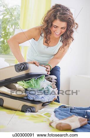 Stock Image - Woman packing suitcase . Fotosearch