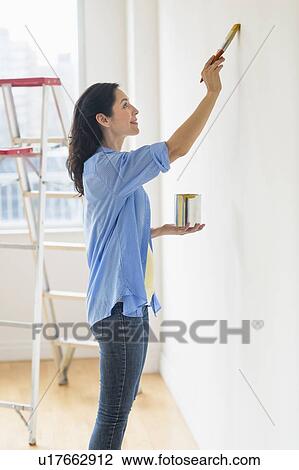 Woman painting wall at home View Large Photo Image Stock Image - Woman painting wall at home. Fotosearch