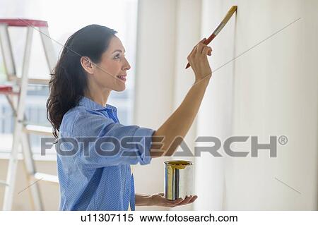 Woman painting wall at home View Large Photo Image Stock Photography - Woman painting wall at home. Fotosearch