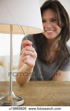 Woman pulling lamp switch View Large Photo Image Stock Photograph - Woman pulling lamp switch. Fotosearch