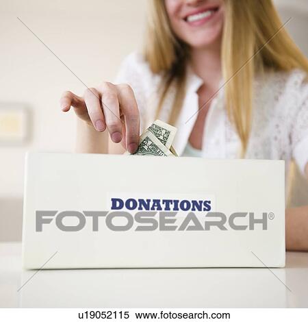 Woman putting money into donation box View Large Photo Image Stock Photography - Woman putting money into donation box. Fotosearch