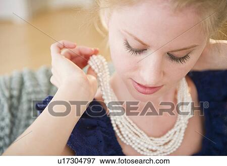 Woman putting on pearl necklace View Large Photo Image Stock Photo - Woman putting on pearl necklace. Fotosearch