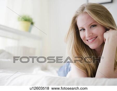 Woman relaxing on bed View Large Photo Image Stock Photo - Woman relaxing on bed. Fotosearch