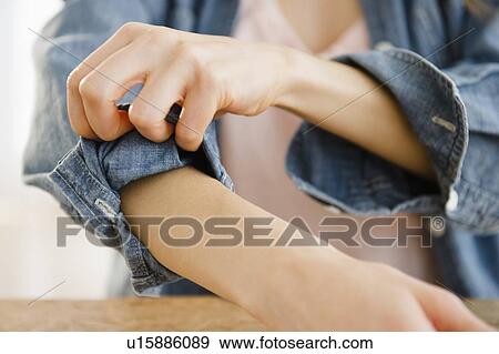 Woman rolling up sleeve View Large Photo Image Stock Photo - Woman rolling up sleeve. Fotosearch