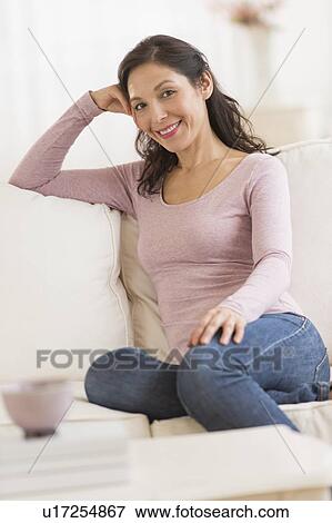Stock Photo - Woman sitting o sofa. Fotosearch