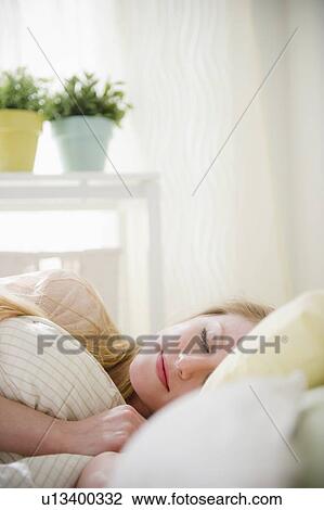 Stock Image - Woman sleeping in bed. Fotosearch