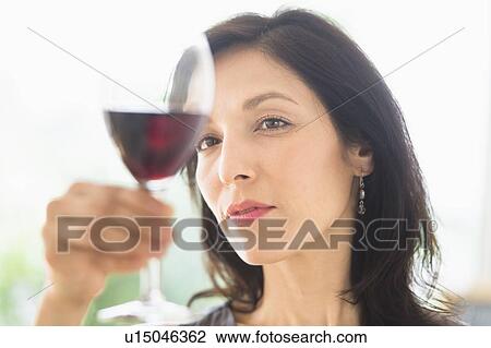Stock Image - Woman tasting red wine. Fotosearch
