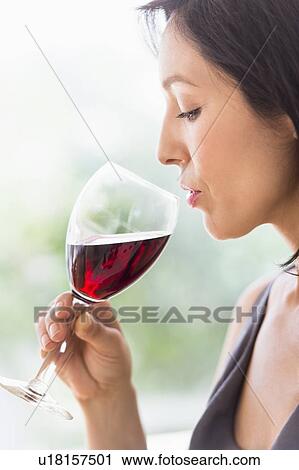 Stock Image - Woman tasting red wine. Fotosearch