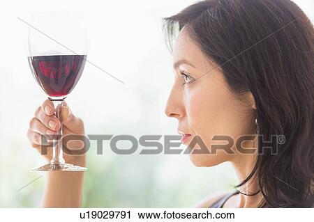 Stock Image - Woman tasting red wine. Fotosearch