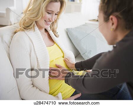 Woman touching belly of pregnant friend View Large Photo Image Stock Image - Woman touching belly of pregnant friend. Fotosearch