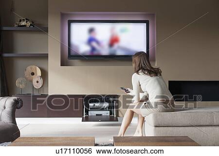 Woman watching television View Large Photo Image Stock Photograph - Woman watching television. Fotosearch
