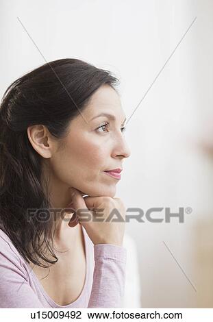 Stock Image - Woman with hand on chin. Fotosearch