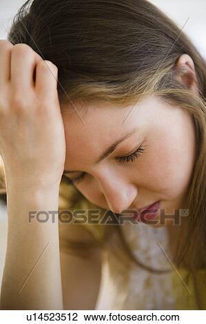 Stock Image - Woman with head in hands. Fotosearch