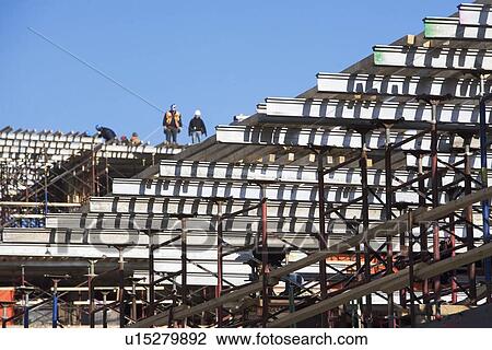 Stock Image - Workers on construction frame. Fotosearch