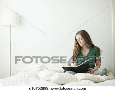 Young attractive woman reading in bed View Large Photo Image Stock Photo - Young attractive woman reading in bed. Fotosearch