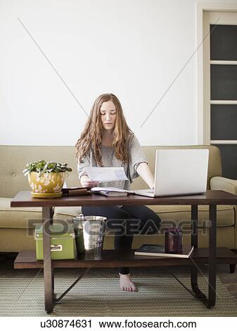 Young attractive woman using laptop while sitting on sofa View Large Photo Image Stock Image - Young attractive woman using laptop while sitting on sofa. Fotosearch
