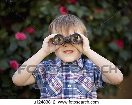 Young boy (6-7) looking through binoculars View Large Photo Image Stock Image - Young boy (6-7) looking through binoculars. Fotosearch