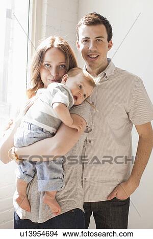 Young couple embracing baby boy (6-11 months) View Large Photo Image Picture - Young couple embracing baby boy (6-11 months) . Fotosearch