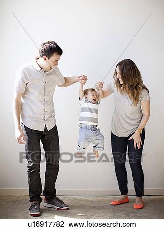 Young couple lifting baby boy (6-11 months) View Large Photo Image Stock Image - Young couple lifting baby boy (6-11 months) . Fotosearch