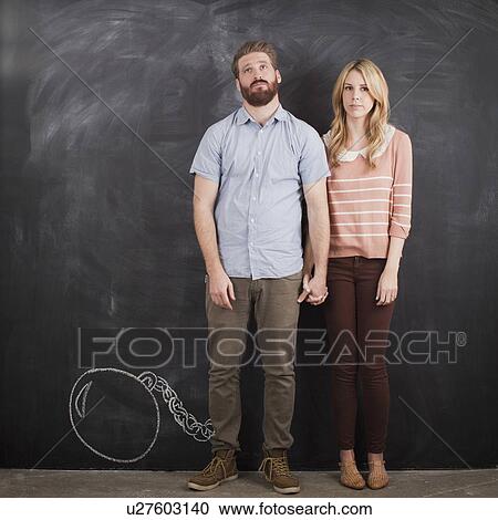 Young couple with blackboard in background, studio shot View Large Photo Image Stock Image - Young couple with blackboard in background, studio shot. Fotosearch