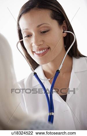 Young doctor examining senior patient View Large Photo Image Stock Image - Young doctor examining senior patient. Fotosearch