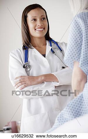 Young doctor talking with senior patient View Large Photo Image Stock Image - Young doctor talking with senior patient. Fotosearch