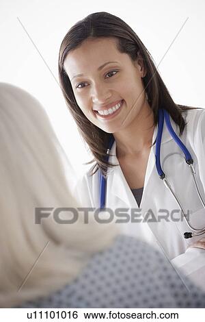 Stock Photograph - Young doctor talking with senior patient. Fotosearch