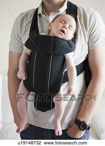 Young father holding baby daughter (2-3 months) in carrycot View Large Photo Image Stock Image - Young father holding baby daughter (2-3 months) in carrycot. Fotosearch