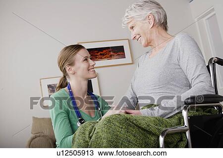 Young female nurse taking care of senior woman View Large Photo Image Stock Image - Young female nurse taking care of senior woman. Fotosearch