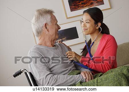 Young female nurse taking care of senior man View Large Photo Image Stock Photo - Young female nurse taking care of senior man. Fotosearch