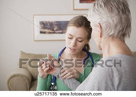 Young female nurse taking pulse of senior woman View Large Photo Image Stock Photography - Young female nurse taking pulse of senior woman. Fotosearch