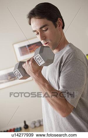 Young man exercising with dumbbell View Large Photo Image Stock Photo - Young man exercising with dumbbell. Fotosearch