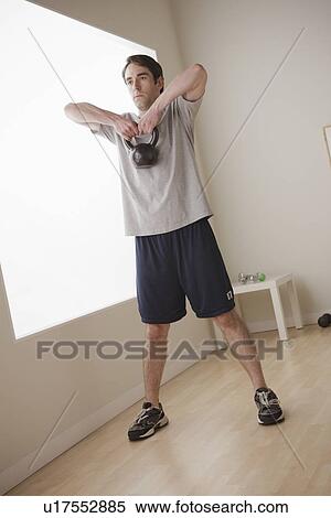 Stock Photography - Young man exercising with weight. Fotosearch