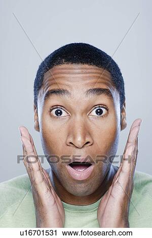 Young man looking surprised, studio shot View Large Photo Image Stock Image - Young man looking surprised, studio shot. Fotosearch