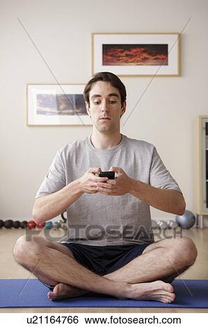 Young man meditating with mobile View Large Photo Image Stock Photograph - Young man meditating with mobile. Fotosearch