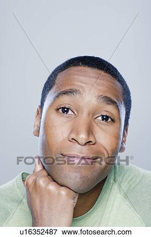 Young man smiling, studio shot View Large Photo Image Stock Photo - Young man smiling, studio shot. Fotosearch